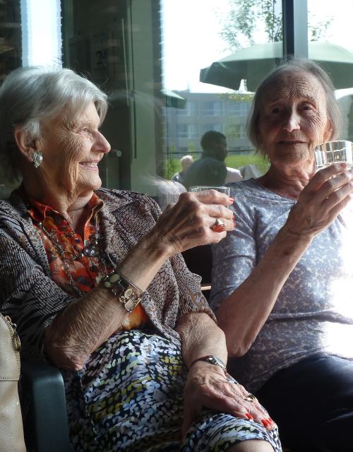 Twee oudere dames genieten samen van een drankje